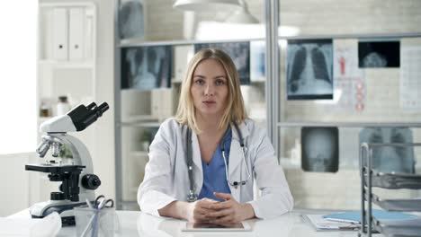 Médico-de-la-mujer-hablando-con-el-paciente-en-línea