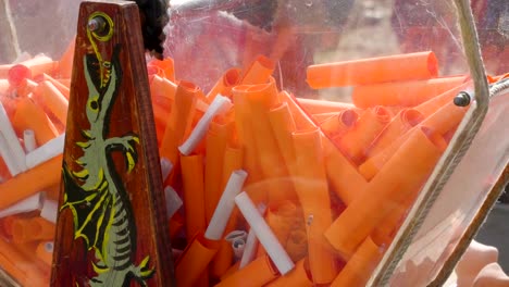 Orange-and-white-rolled-papers-inside-the-glass-box