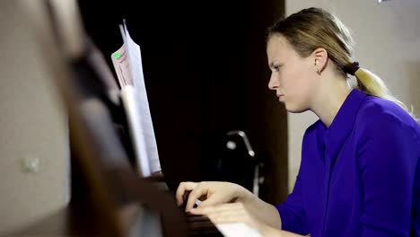 Teen-girl-plays-on-the-keyboard-of-the-digital-piano.