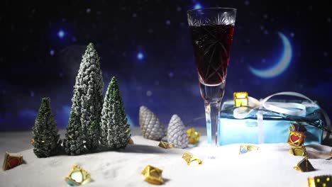 Glas-Wein-mit-Weihnachtsdekoration.-Rotwein-in-Kristall-Glas-auf-Schnee-mit-kreativen-Neujahr-Kunstwerk.-Textfreiraum