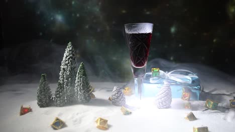 Glass-of-wine-with-Christmas-decoration.-Red-wine-in-crystal-glass-on-snow-with-creative-New-Year-artwork.-Copy-space