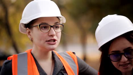 The-engineer-communicates-with-the-female-customer-representatives-at-the-construction-site,-checking-the-drawings-with-the-actual-progress-of-construction-work