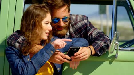 Cute-couple-discussing-on-mobile-phone-on-a-sunny-day-4k