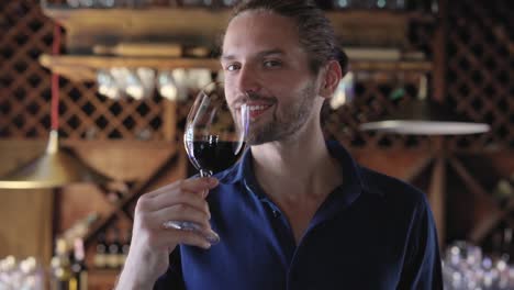 Hombre-bebiendo-vino-tinto-de-cristal-en-el-restaurante-de-la-bodega