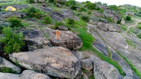 Hombre-joven-caminando-y-de-pie-sobre-las-rocas