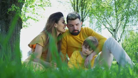 Family-reading-a-book-outdoors