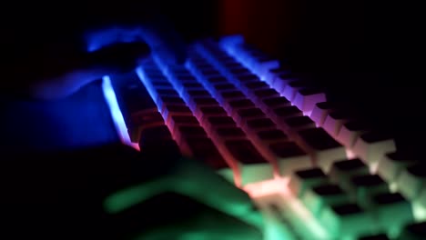 Close-view-of-Esport-athlete,-gamer-playing-on-RGB-keyboard-with-colorful-lights