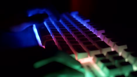 Nahansicht-von-Esport-Sportler,-Gamer-spielen-auf-RGB-Tastatur-mit-bunten-Lichtern