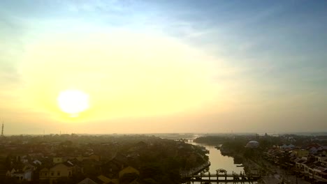 bright-sun-rises-above-dark-city-with-river