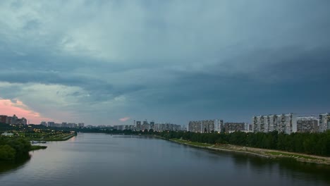 Cityscape-with-river-traffic-and-movement-of-the-clouds-at-dusk