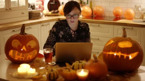 Frau-mit-Laptop-inmitten-Halloween-Dekorationen