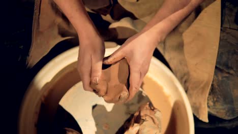 A-close-view-on-potters-hands-kneading-clay.