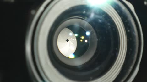 Video-camera-lens,-showing-zoom-and-glare,-turns,-close-up