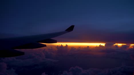 TEXTFREIRAUM:-Große-Flugzeugflügel-durch-schönen-lila-und-orange-Himmel-fliegen.