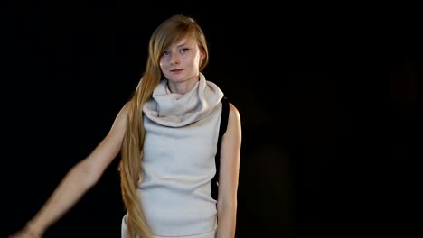 blonde-model-of-European-appearance-posing-in-front-of-camera-in-studio-on-black-background