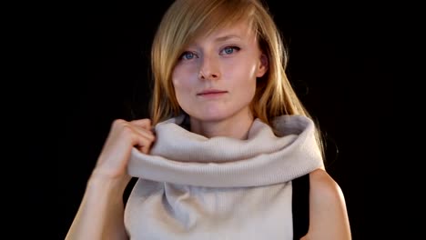 blonde-model-of-European-appearance-posing-in-front-of-camera-in-studio-on-black-background