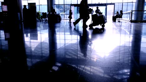 Silhouetten-von-Reisenden-Passagiere-im-Flughafen-transit-terminal-zu-Fuß-mit-Gepäck-Gepäck-gehen,-Reisen