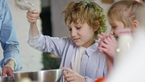 Boy-Sifting-Flour-into-Metal-Bowl