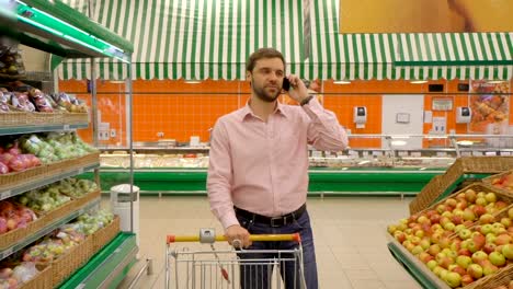 Male-customer-using-mobile-phone-in-food-market