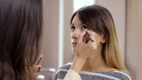 maquillaje-profesional-en-el-salón-de-belleza-master-pone-un-maquillaje-profesional-verano-fresco-de-una-hermosa-modelo-en-el-salón