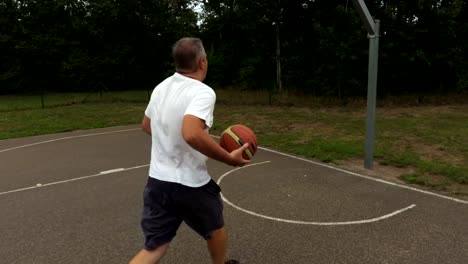 Camera-follows-a-man-with-a-basketball-ball