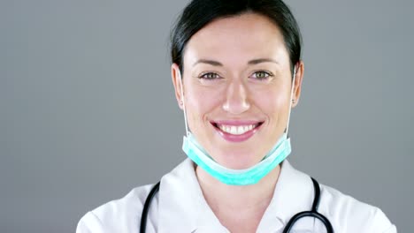 Portrait-of-a-female-doctor-with-white-coat-and-stethoscope-smiling-looking-into-camera-on-white-background.