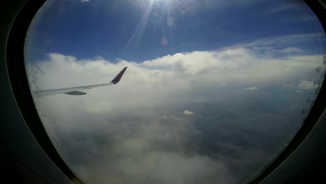 Airplane-Wing-Flying-Through-Clouds-Above-The-City