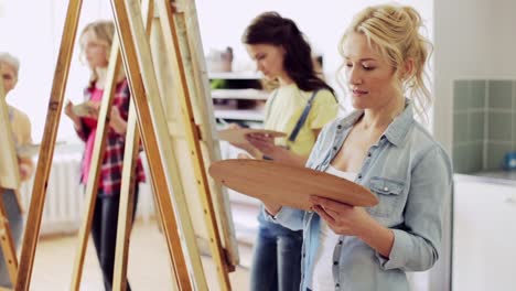 students-with-easels-painting-at-art-school