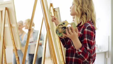 students-with-easels-painting-at-art-school