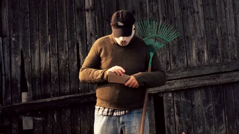 Man-in-Halloween-mask-with-a-rake-and-a-knife