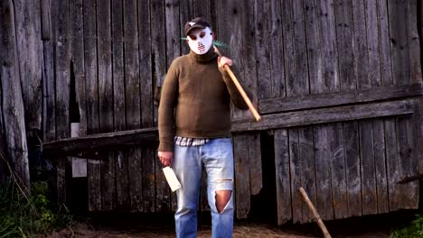 Man-in-Halloween-mask-with-a-rake-and-a-knife