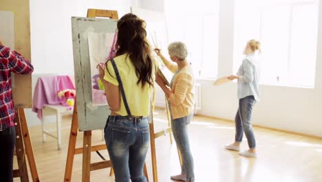 estudiantes-con-caballetes-de-pintura-en-la-escuela-de-arte