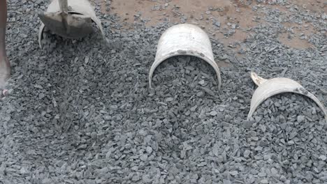 Using-a-shovel-to-put-gravel-into-a-bucket-(-close-up)