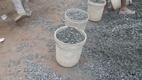 Using-a-shovel-to-put-gravel-into-a-bucket-(-close-up)