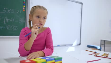 Schultag,-weibliche-Schüler-schreibt-eine-Aufgabe-in-Heft-an-der-Rezeption-in-einem-Klassenzimmer-auf-Hintergrund-von-blackboard