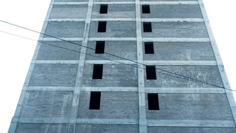 Multi-storey-under-construction-building-and-construction-crane-on-the-background-of-clear-sky.