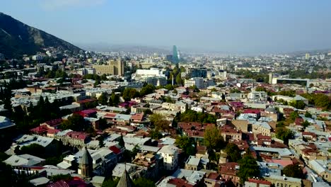 Aerial-View-Of-The-Old-Part-Tbilisi-City-In-Georgia-Tile-Roofs,-Church-Modern-Buildings.-Drone-flight