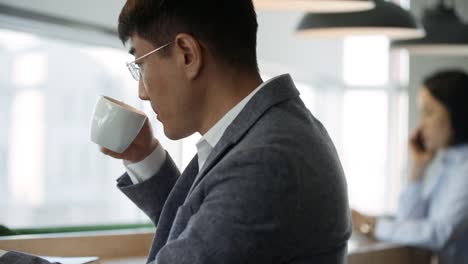 Businessman-Drinking-Tea-and-Using-Laptop