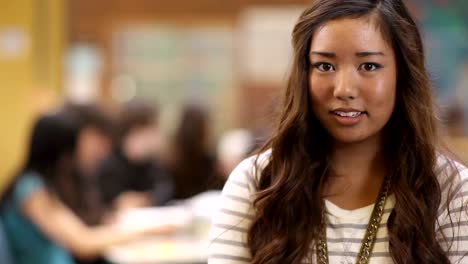 Un-estudiante-universitario-femenino-asiático-lindo-mira-hacia-la-cámara-y-sonríe