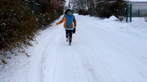 Erwachsene-Frau-macht-Spaß-zu-Fuß-auf-einer-verschneiten-Straße.