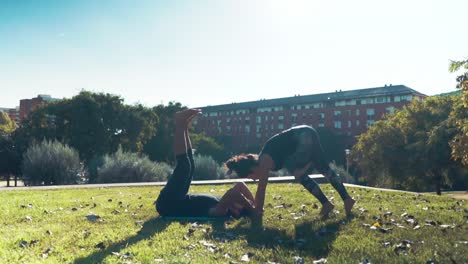 Schönes-paar-praktizieren-Acro-Yoga-am-Morgen