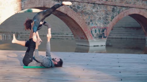 Schönes-paar-praktizieren-Acro-Yoga-am-Morgen