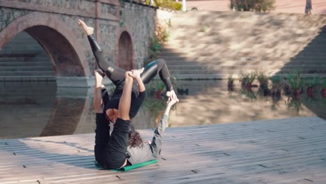 Schönes-paar-praktizieren-Acro-Yoga-am-Morgen