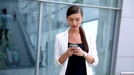 Beautiful-Woman-With-Phone-Walking-Near-Business-Office