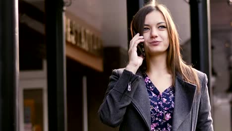 Close-up-portrait-of-attractive-caucasian-businesswoman-walking-on-the-street-on-the-office-building-background