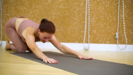 Junge-Frau-Verlegung-auf-Matte,-Yoga-Übungen-im-Yoga-studio