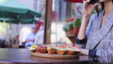 Essen-und-trinken.-Closeup-Frau-trinkt-Wein-mit-Snacks