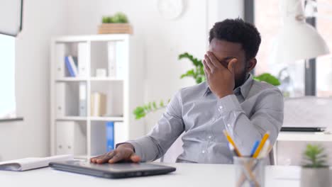 betonte-Geschäftsmann-mit-Laptop-im-Büro