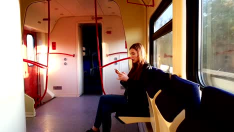 young-woman-using-mobile-phone-on-train