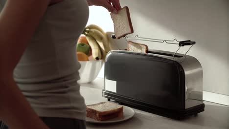 Frühstück.-Frau,-setzen,-schneiden-Brot-im-Toaster-Closeup